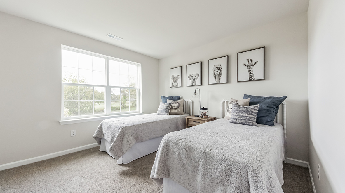 Different view of the bedroom with two twin beds in it with a large double window.