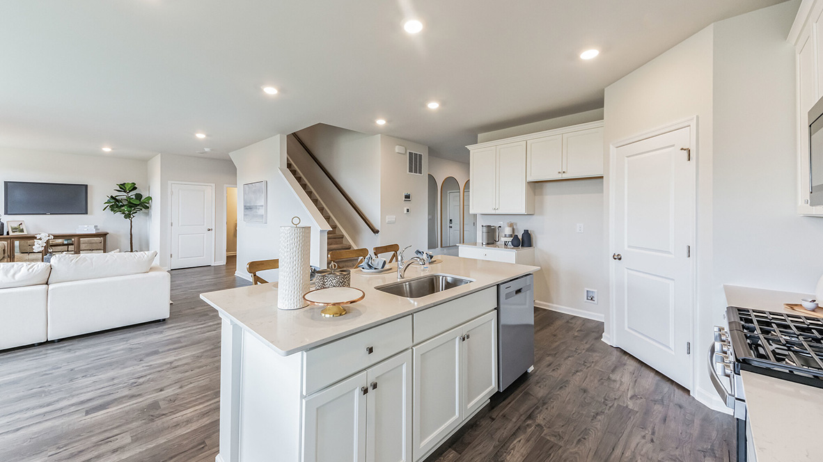 Open layout from the kitchen looking into the living room, stairs, and end of the foyer.