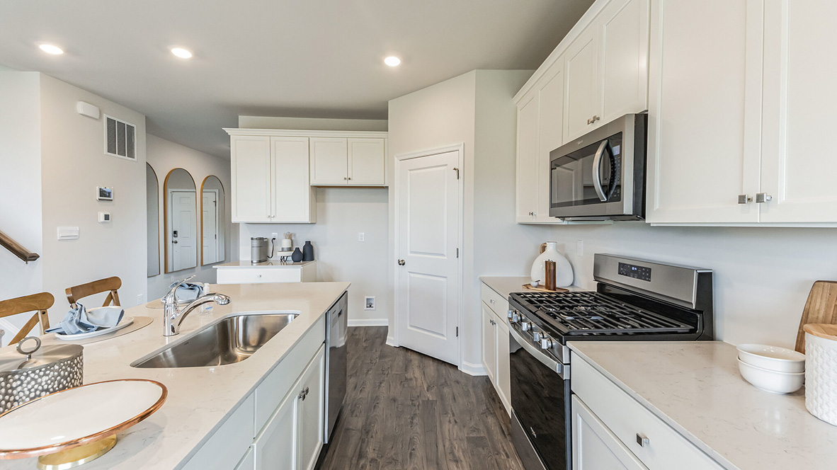 Opposite view of the walkway between the wall of the kitchen and the island.