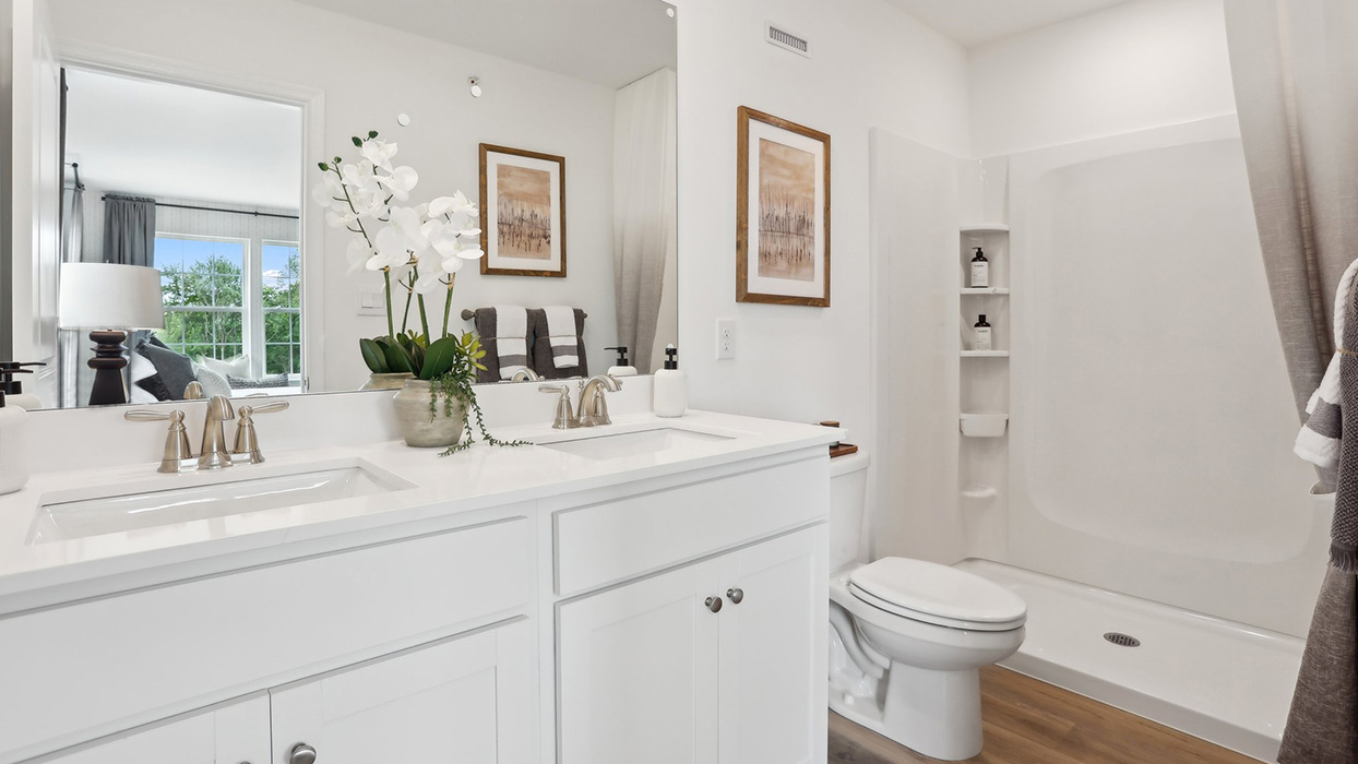 Primary bathroom with double vanity and walk-in shower.