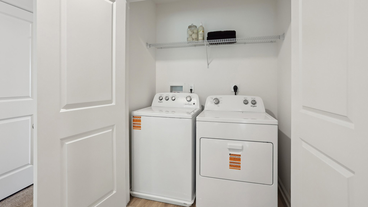 Laundry room with with washer and dryer and shelf above.