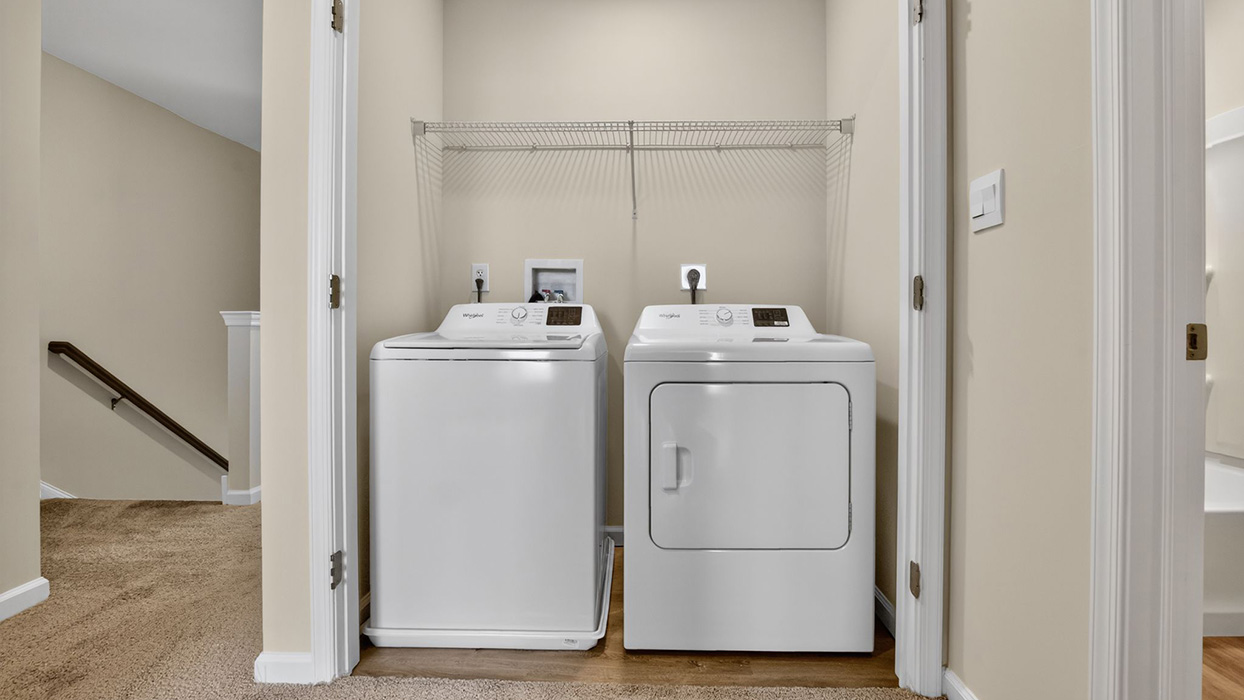 Laundry room with with washer and dryer and shelf above.