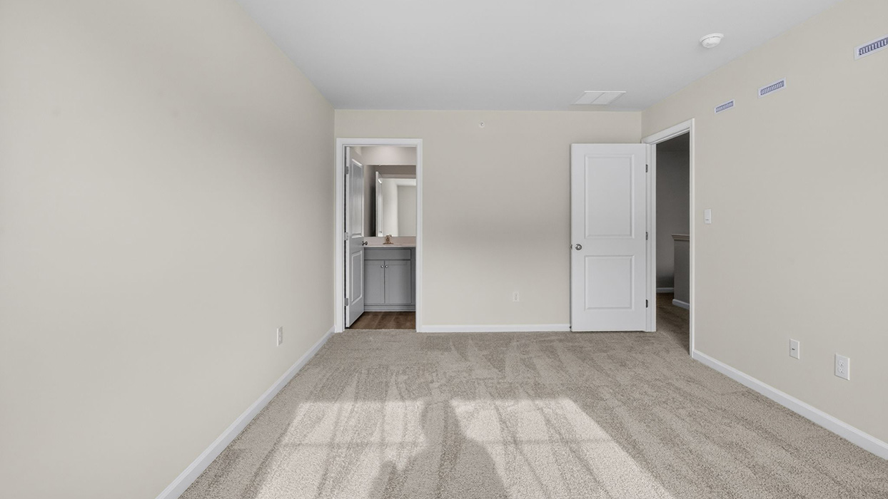 A different view of the primary bedroom with view to bathroom door.