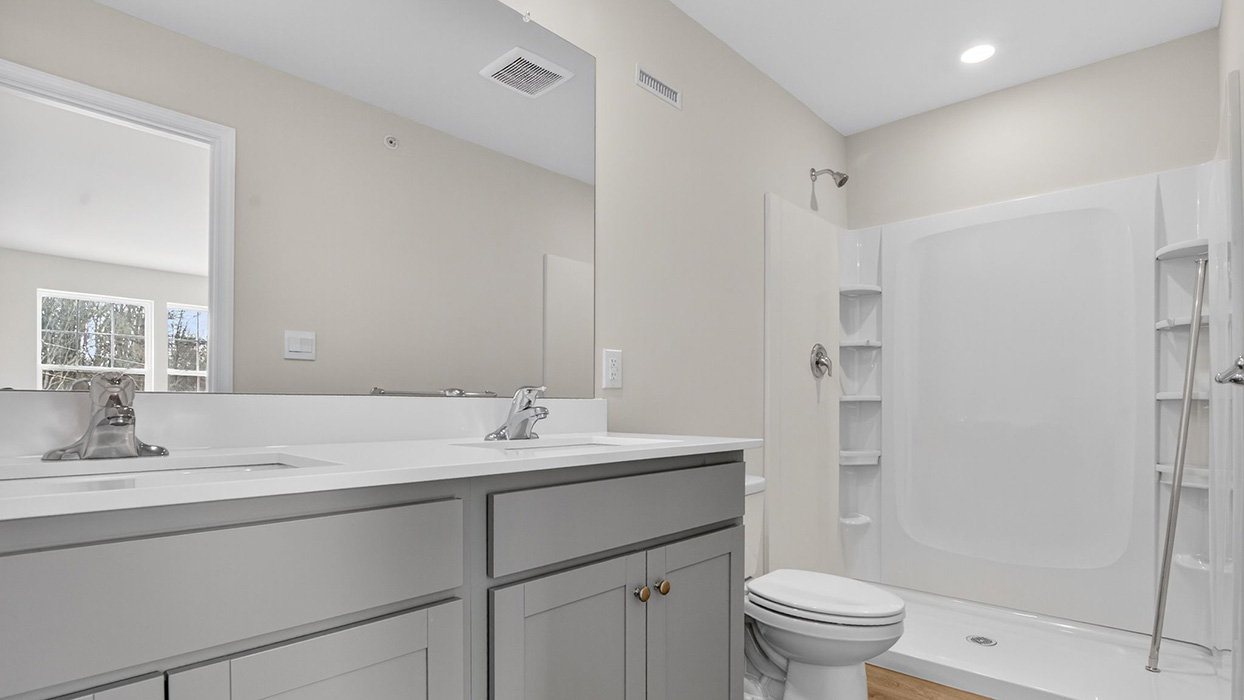 Primary bathroom with double vanity and walk-in shower.
