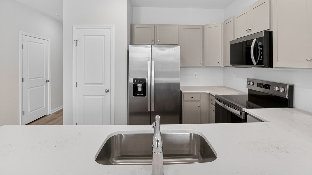 In front of the kitchen counter with view of the sink.