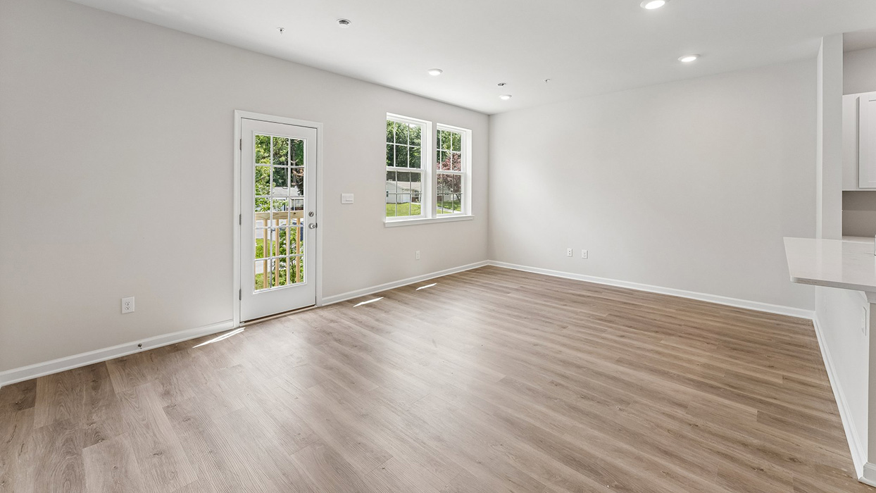 Living and dining area with glass door, double windows, and open layout connecting to kitchen