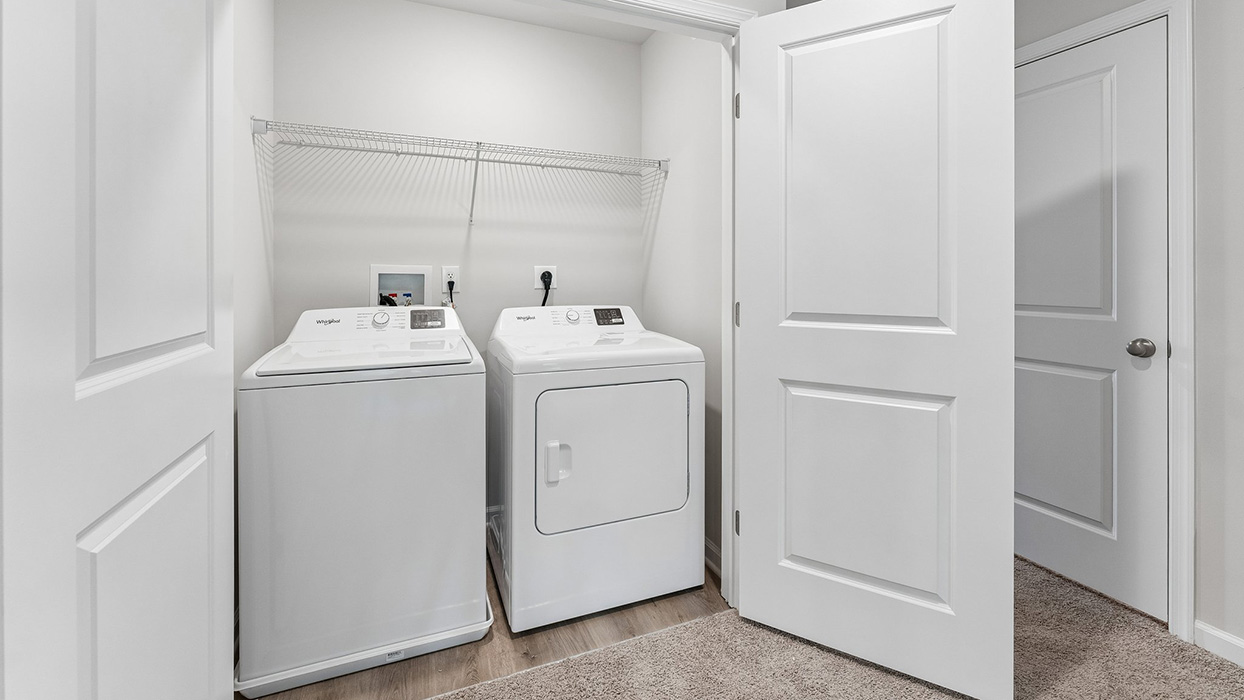 Laundry closet with washer and dryer, overhead wire shelf, and double doors for storage