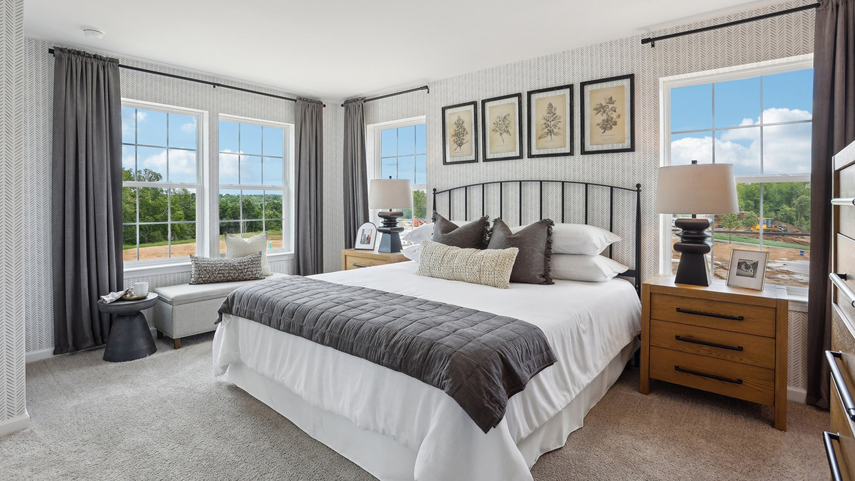 Primary bedroom with large double window and two windows on either side of the bed.