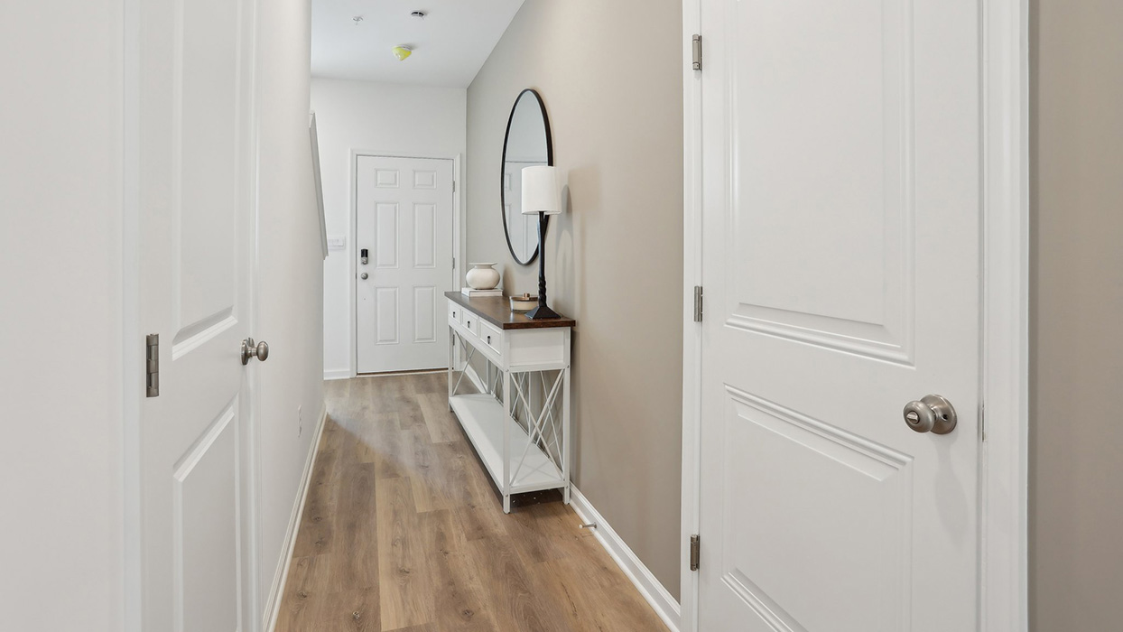 A look back at the foyer entrance front door with the garage entrance door along the right wall.