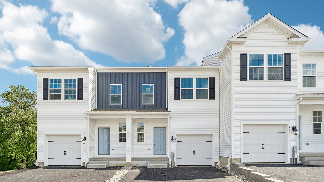 Front elevation of Summit Village Norris model featuring driveway, entryway, and natural curb appeal