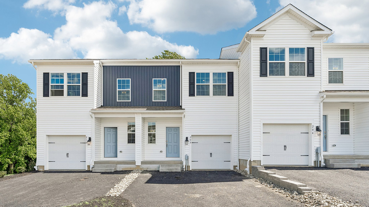 Townhome front elevation with driveways, single-car garages, and contrasting panel detail