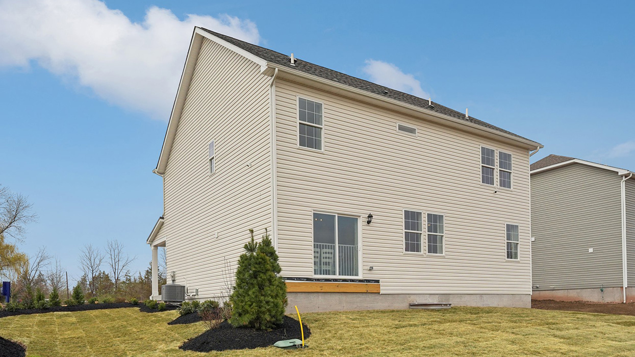 A rear view of a two-story home with horizontal plank siding in linen.