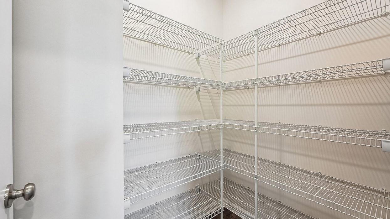 Walk-in pantry in the Galen single-family home at Creekside Village with multiple wire shelving levels providing ample kitchen storage space.