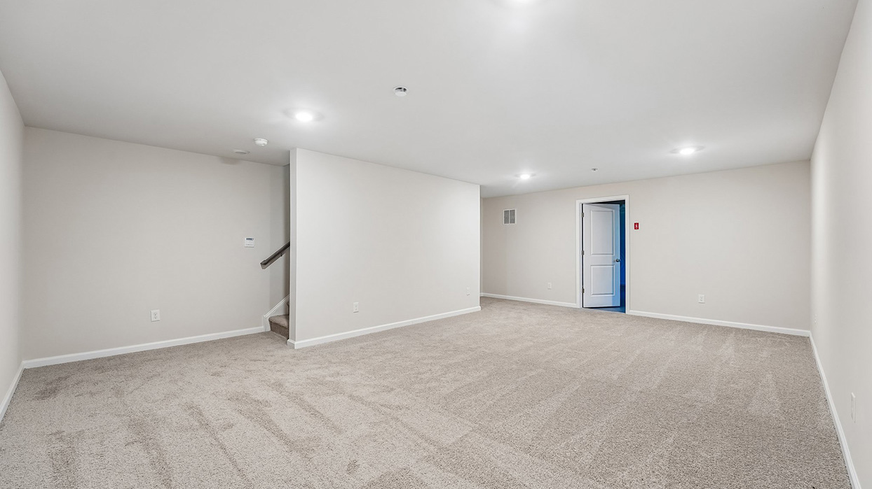 Spacious finished basement in the Galen single-family home at Creekside Village with an open layout, recessed lighting, and stair access to the main level.