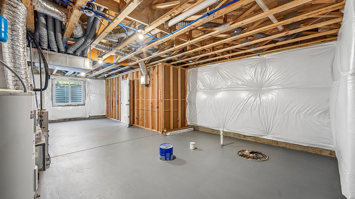 Unfinished basement storage area in the Galen single-family home at Creekside Village featuring mechanical systems, utility access, and additional storage potential.