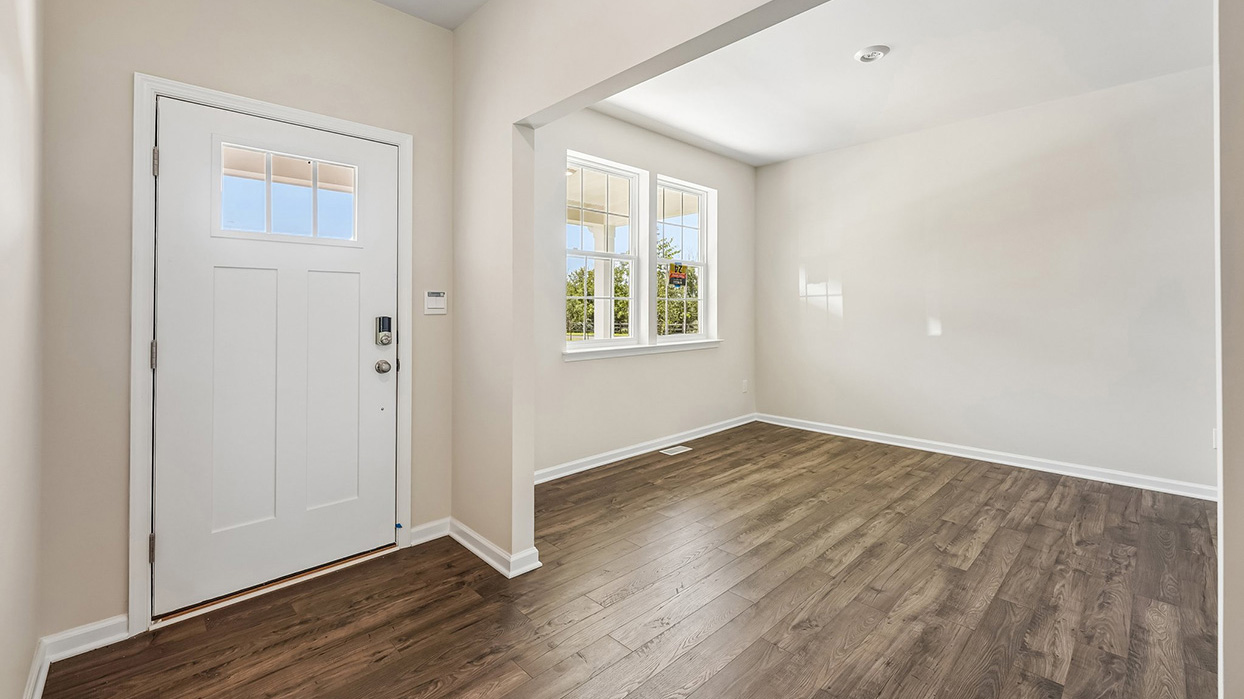 Flex room inside the Galen single-family home at Creekside Village featuring luxury vinyl plank flooring, neutral paint, and large front-facing windows.