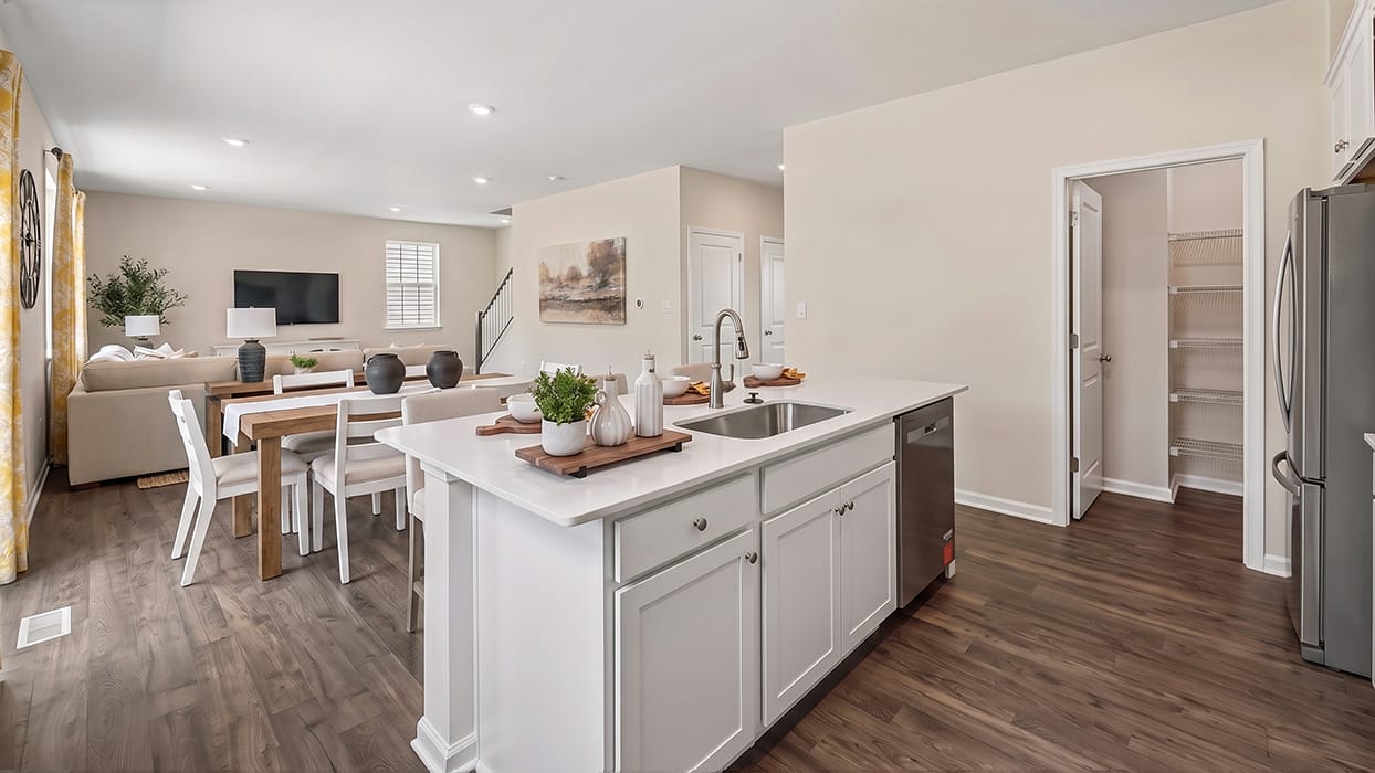 Kitchen and living area view with oversized island, stainless steel dishwasher, and open-concept floor plan