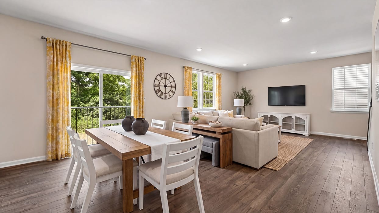 Spacious family room with large windows, sliding glass door, and abundant natural light overlooking backyard