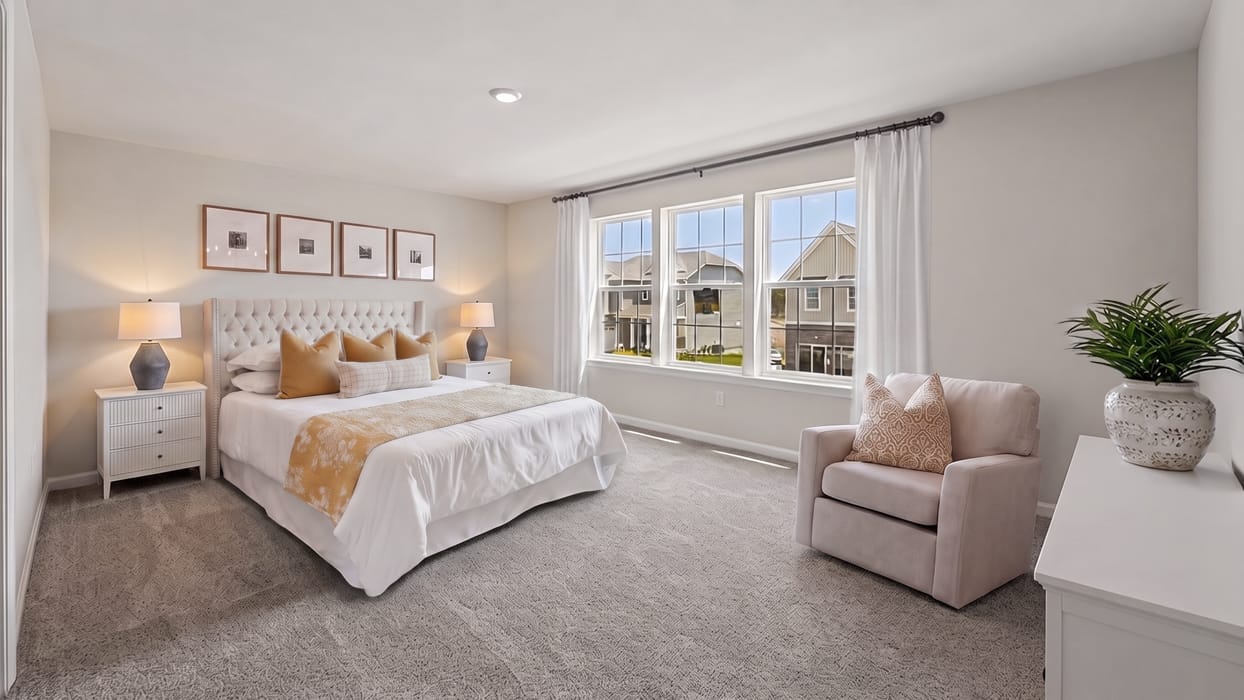 Owner’s suite with multiple windows, soft carpet flooring, and entry to private en-suite bathroom