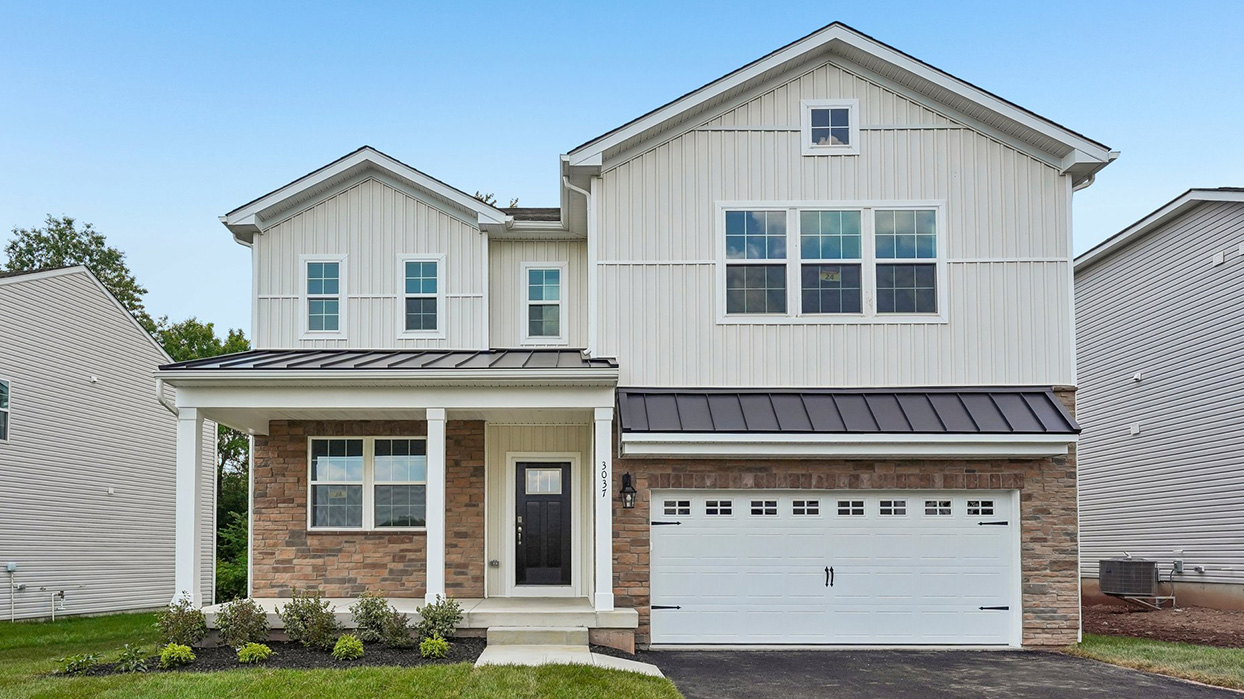 Exterior front view of Galen home with G5 elevation, featuring covered porch, stone accents, and two-car garage in Creekside Village