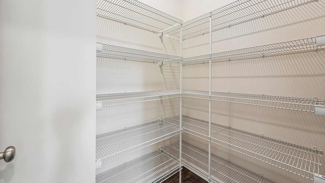 Walk-in pantry with multiple wire shelving racks, providing ample storage and organization space