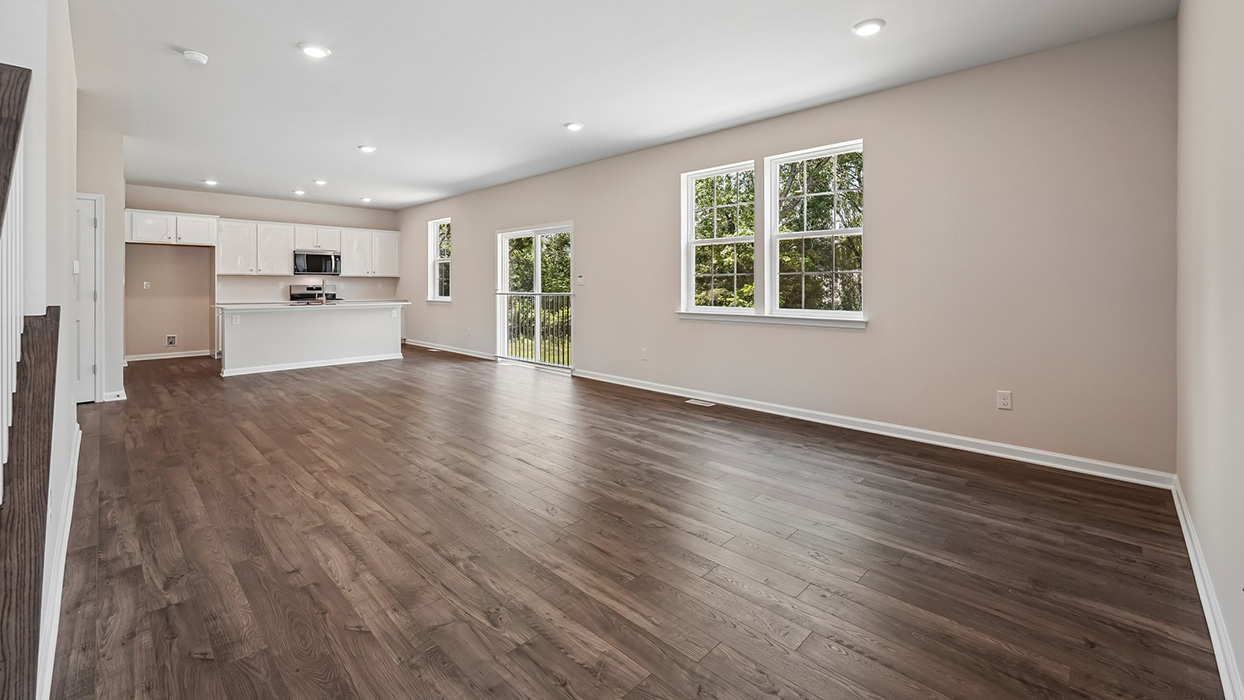 Expansive living and dining area with multiple windows, sliding glass door, and open kitchen layout