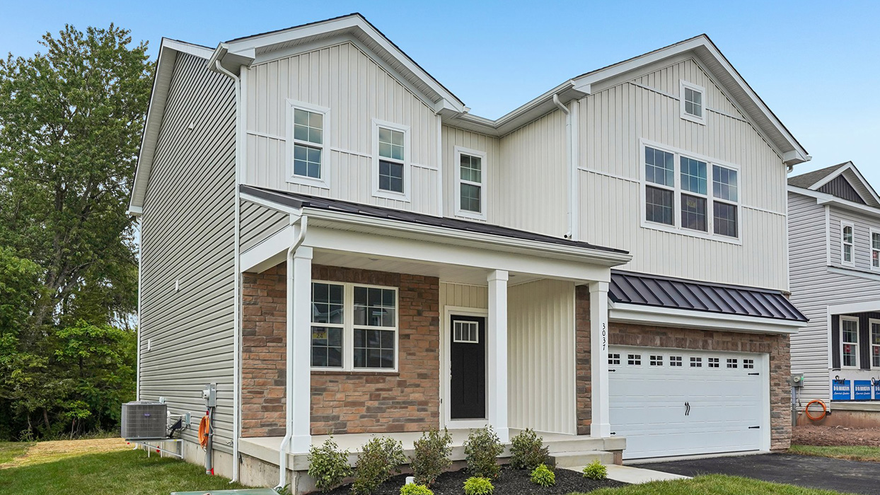Angled exterior view of Galen single-family home with covered front porch, mixed siding, and attached two-car garage