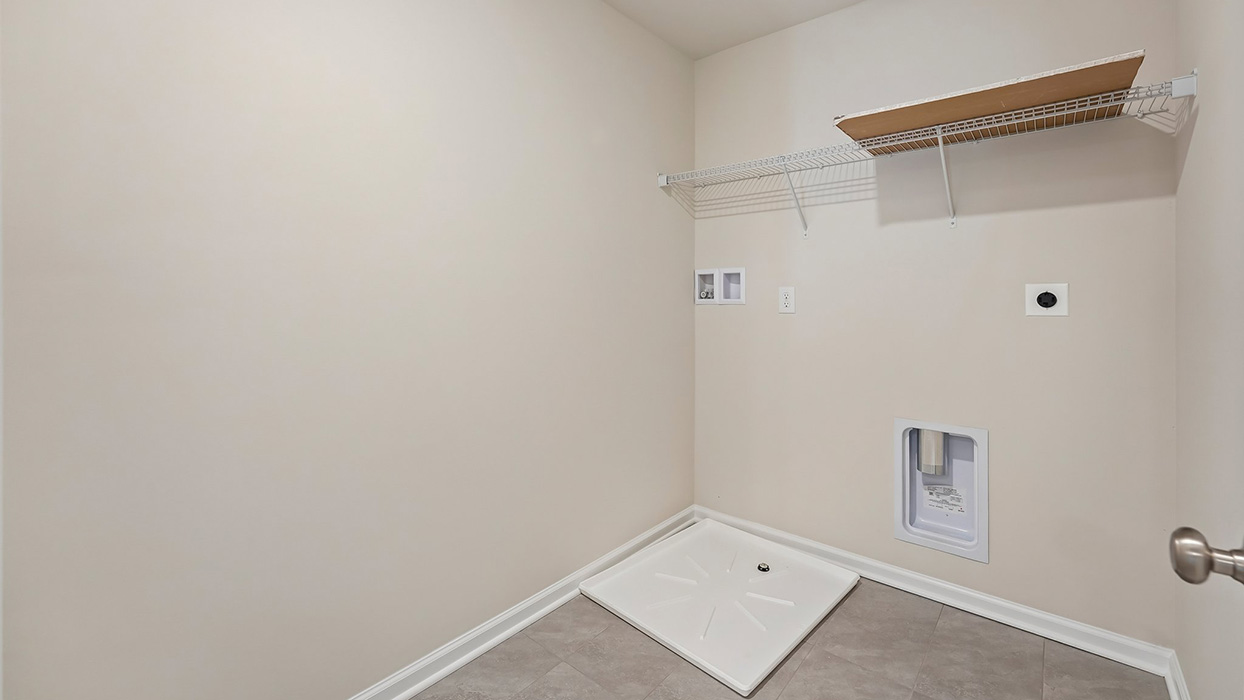 Laundry room with washer hookup, utility sink connections, and overhead storage shelf