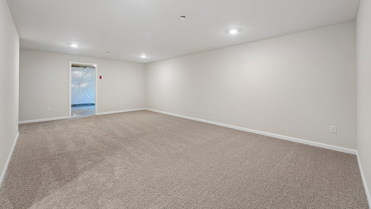 Finished basement recreation area with carpet flooring, recessed lighting, and open flexible layout