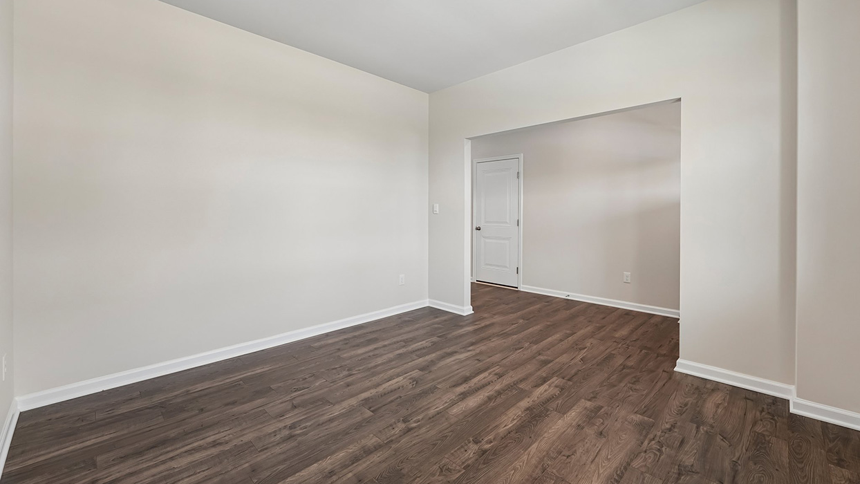 Main-level flex room with wood-look flooring and wide opening, ideal for dining room, office, or sitting area