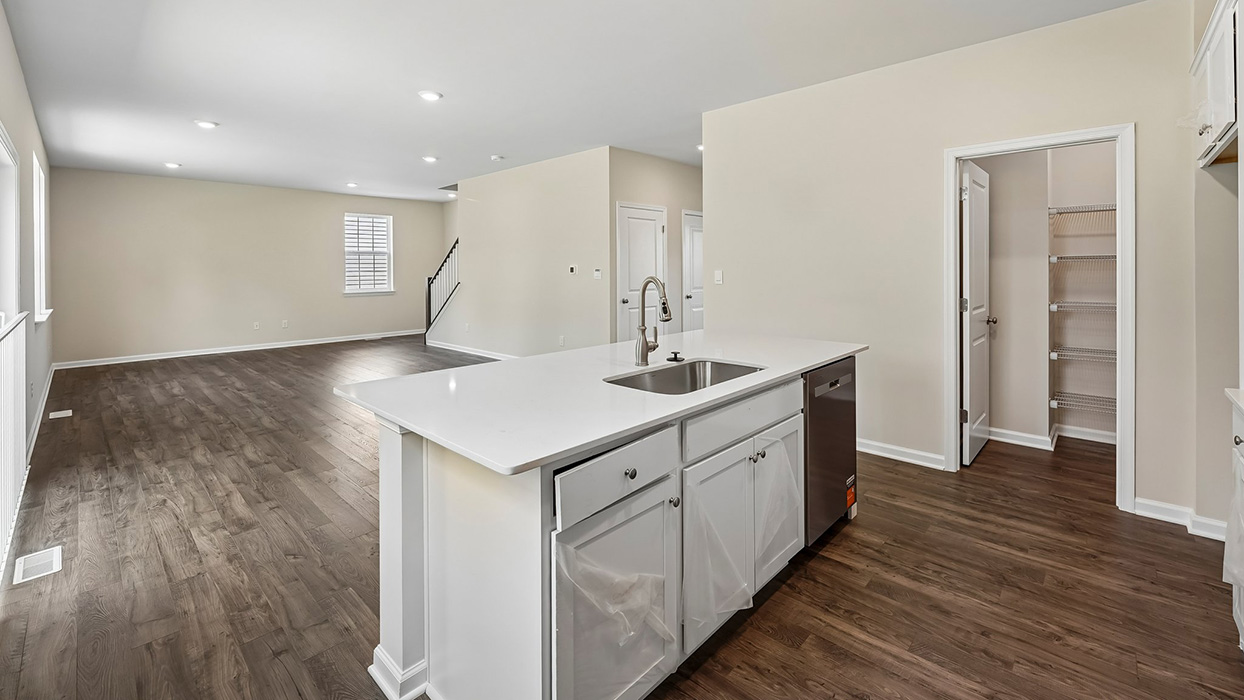Kitchen and living area view with oversized island, stainless steel dishwasher, and open-concept floor plan