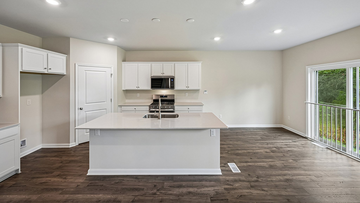 Open-concept kitchen featuring center island with sink, recessed lighting, and adjacent dining area