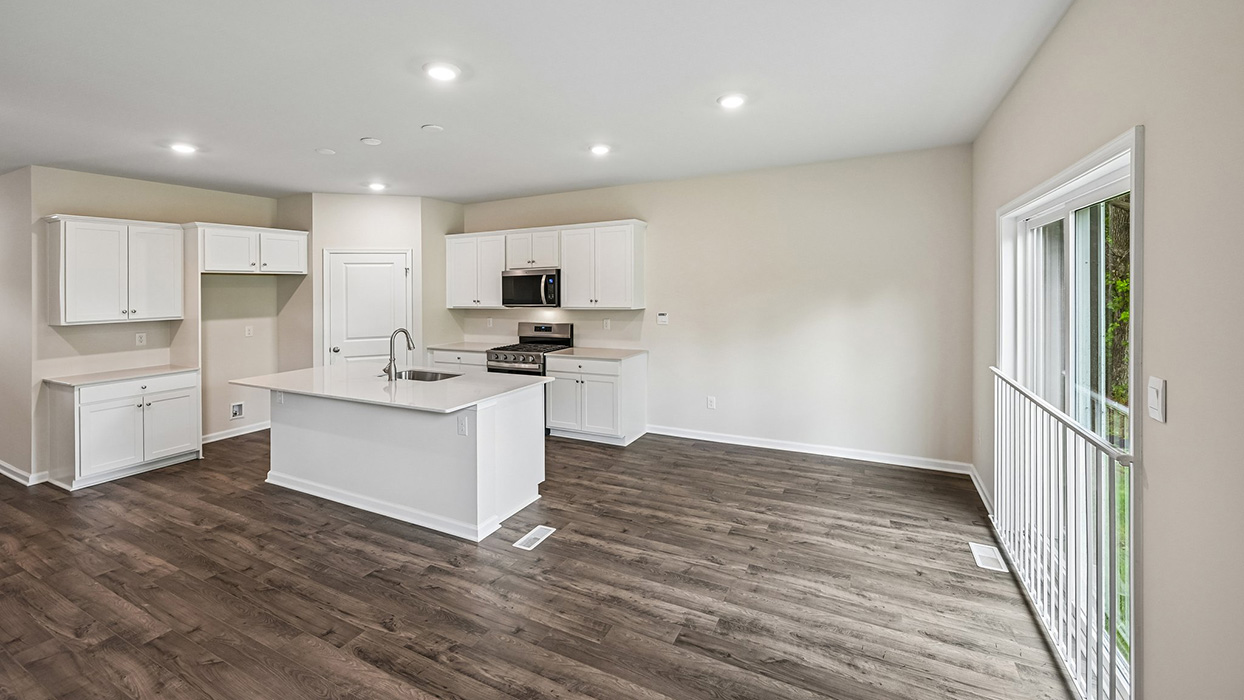 Kitchen and dining area with island workspace, white cabinetry, and sliding glass door access