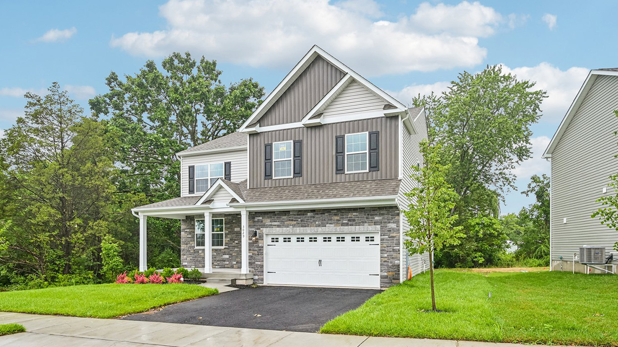 Angled front exterior view highlighting elevation F7 siding, stone accents, driveway, and landscaped front yard