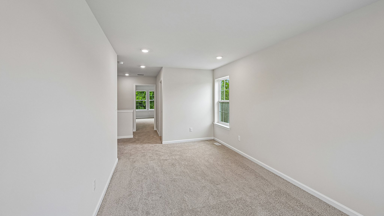 Upstairs loft area with carpet flooring, recessed lighting, and open view toward hallway