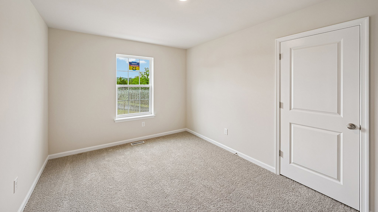 Secondary bedroom featuring plush carpet, single window, and closet door