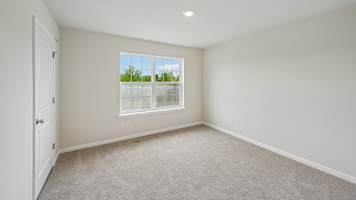Bedroom with large double window, natural light, and neutral finishes