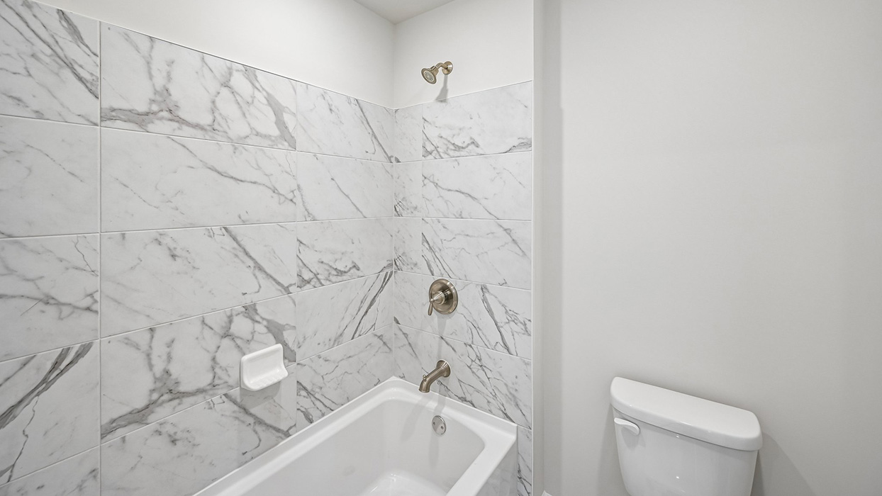 Full bathroom with tub and shower combo featuring tile surround and modern fixtures