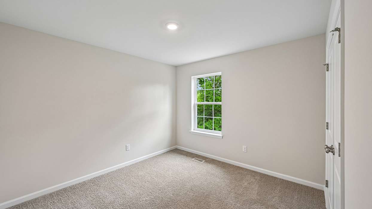 Secondary bedroom with neutral carpet, single window, and clean white trim for natural light