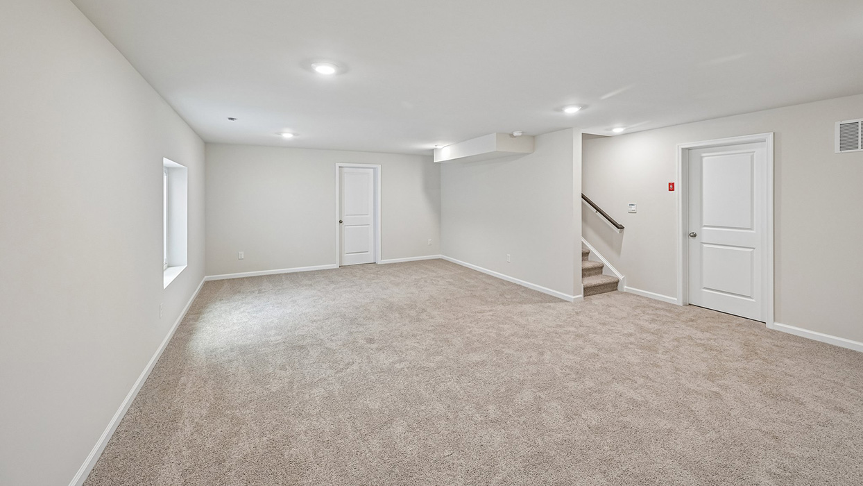 Finished basement with open layout, staircase access, and multiple recessed lights