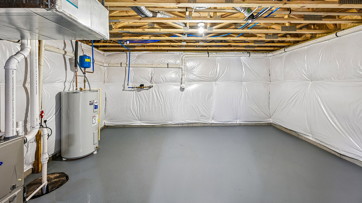 Unfinished basement utility area with HVAC system, water heater, and insulated walls