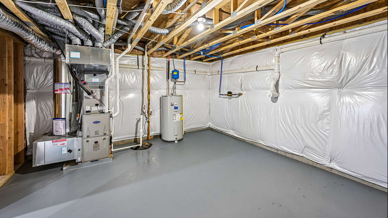 Basement mechanical room with furnace, ductwork, water heater, and open storage space