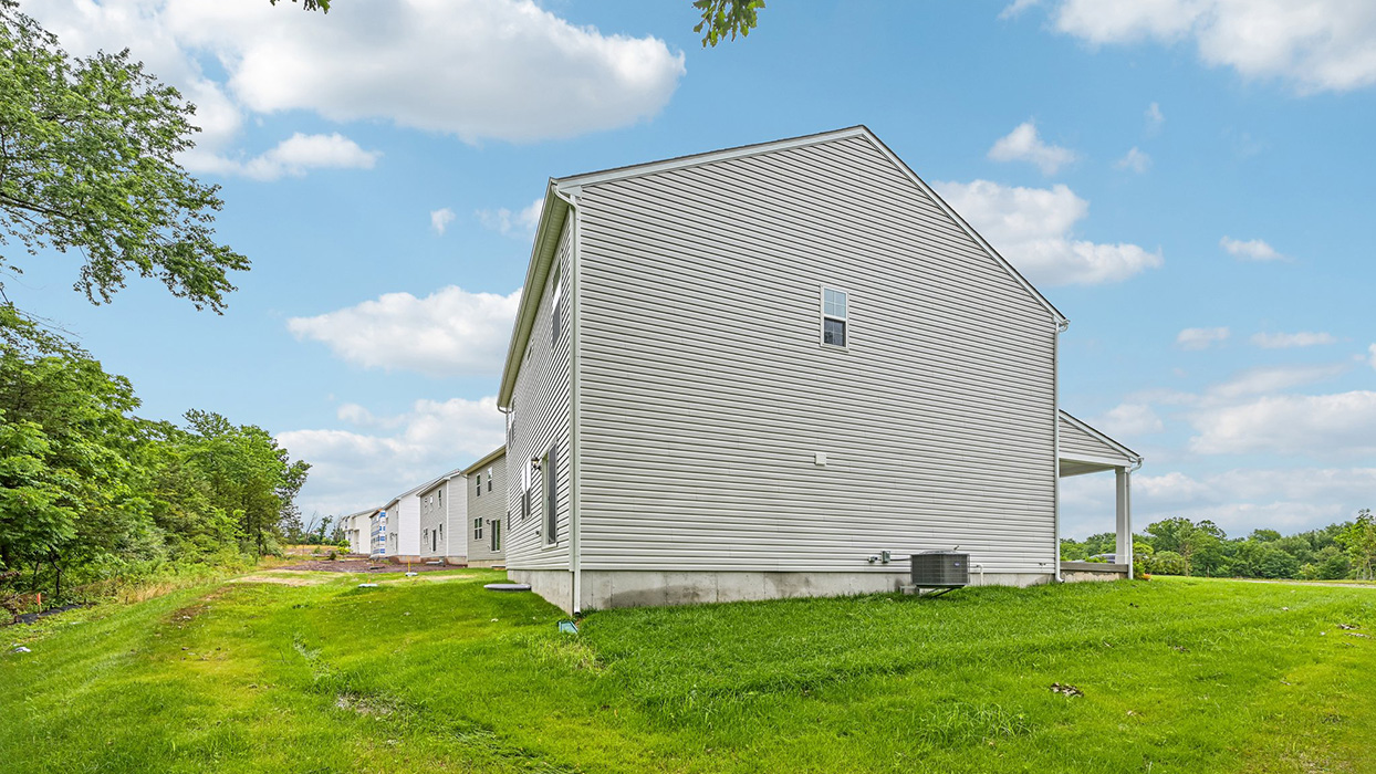 Side yard exterior with vinyl siding, grassy yard, and HVAC unit along foundation