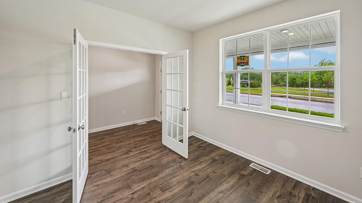 Bright flex space featuring double glass doors and wide window overlooking the front yard