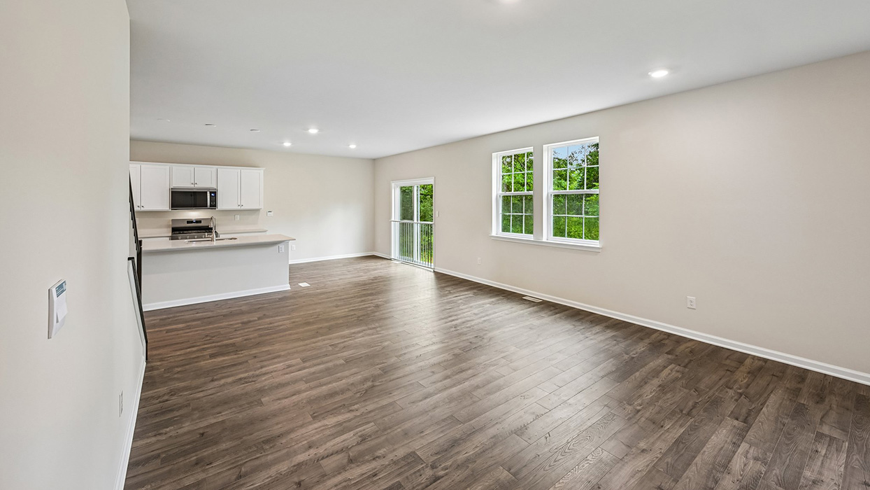 Open-concept living area with spacious layout, large windows, and sliding glass door