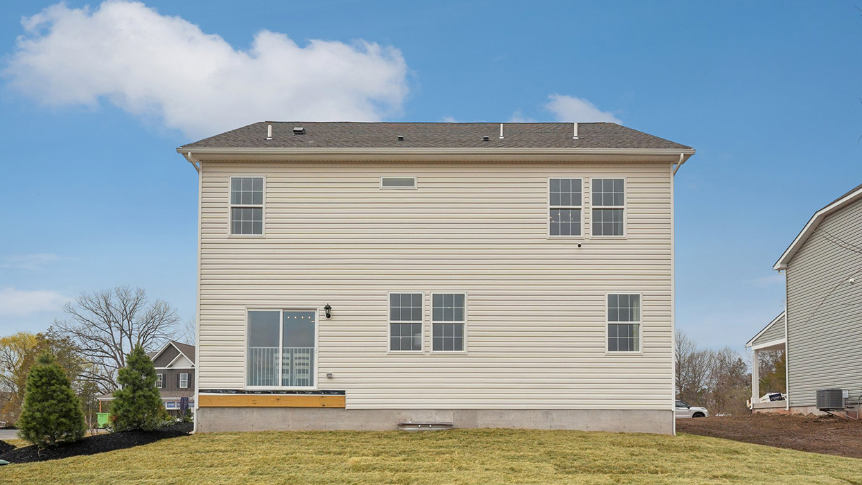 A rear view of a two-story home with horizontal plank siding in linen.