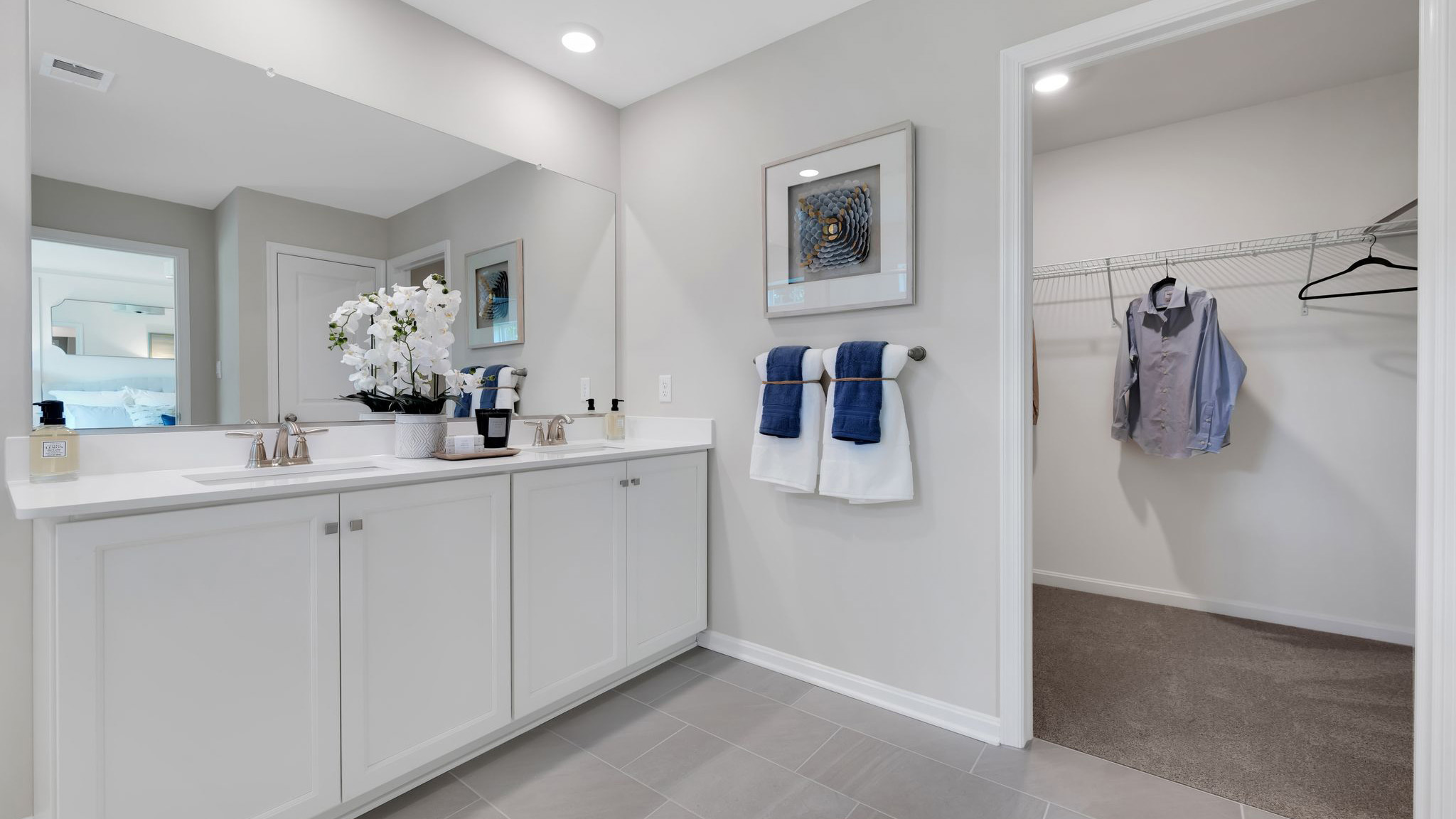 A contemporary owner’s bathroom with double sink and white cabinetry.