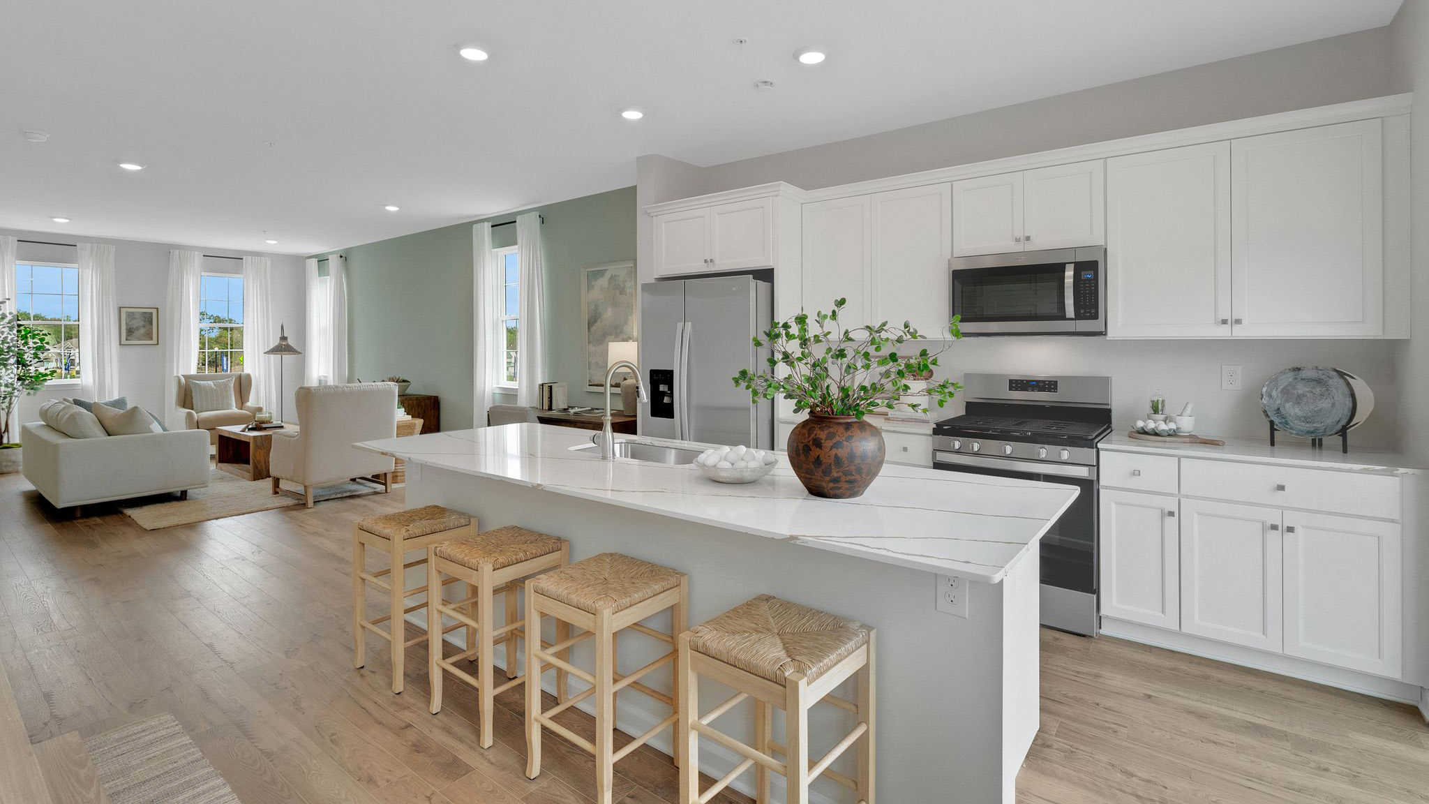 Kitchen area from the point of view of standing next to the glass sliding balcony door. View of the kitchen and and the living area in the back.