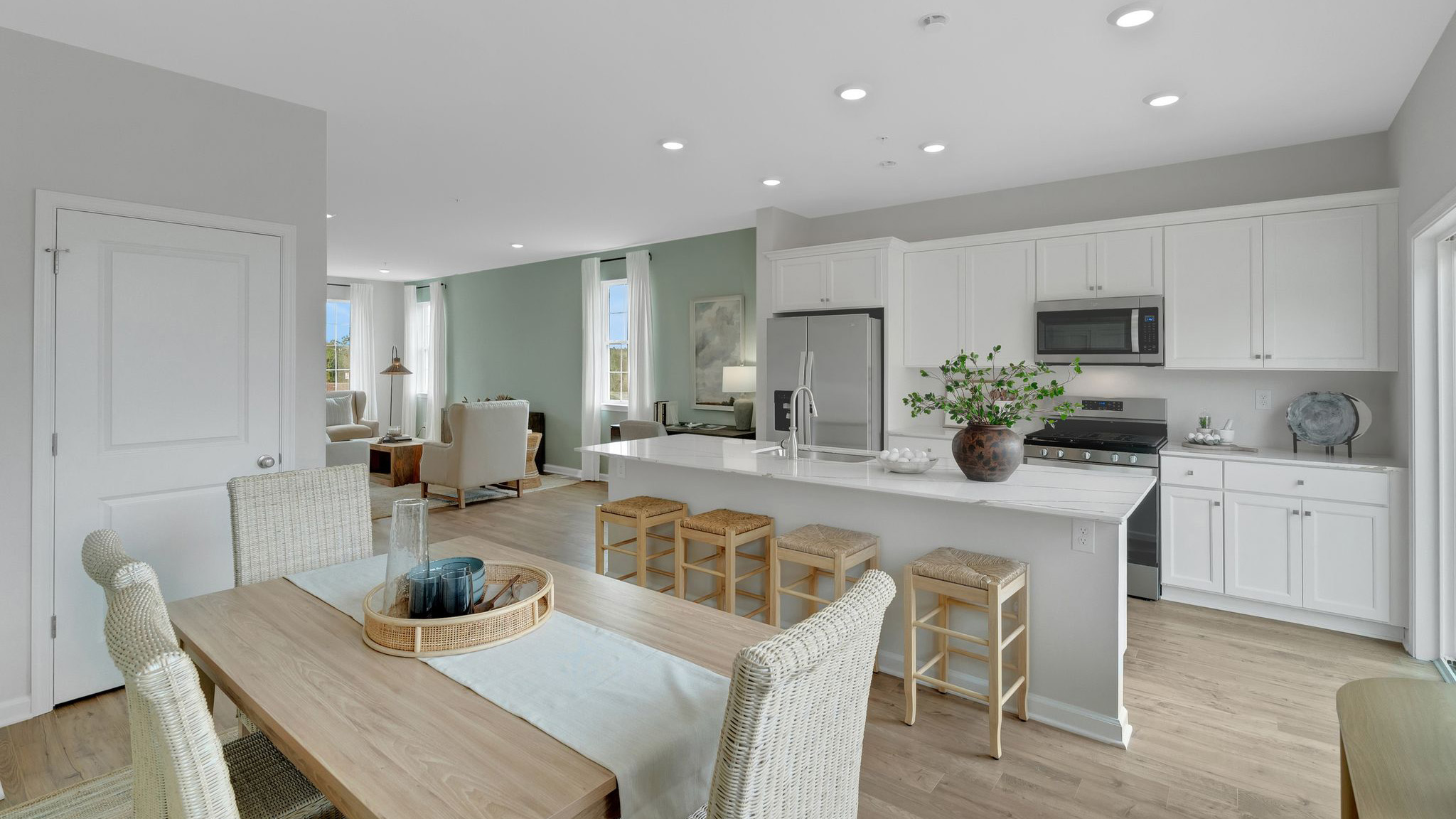 The dining area is situated in front of the kitchen with a large island for barstool seating.