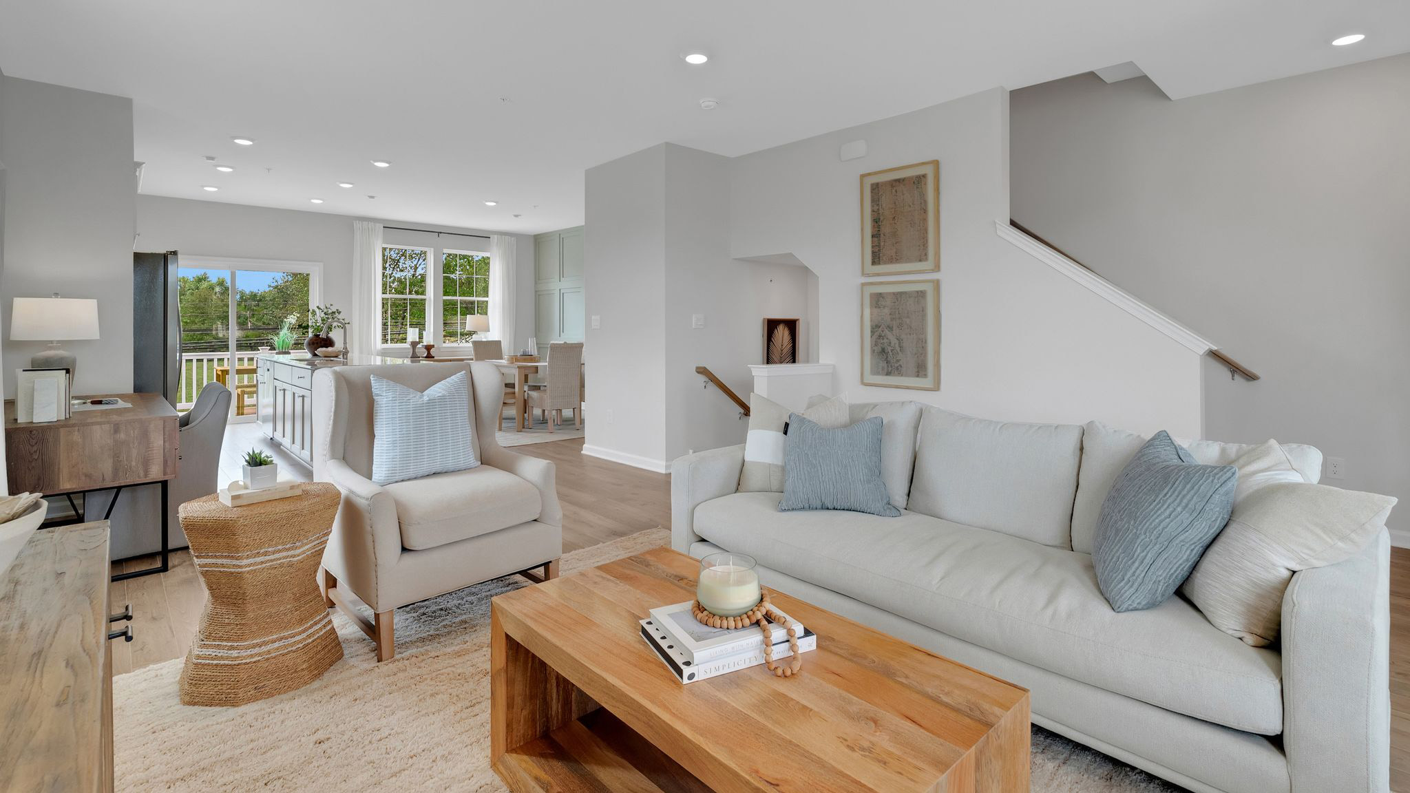 In this view you're able to see the living area up close with the stairs to the right and the dining and kitchen area in the back.